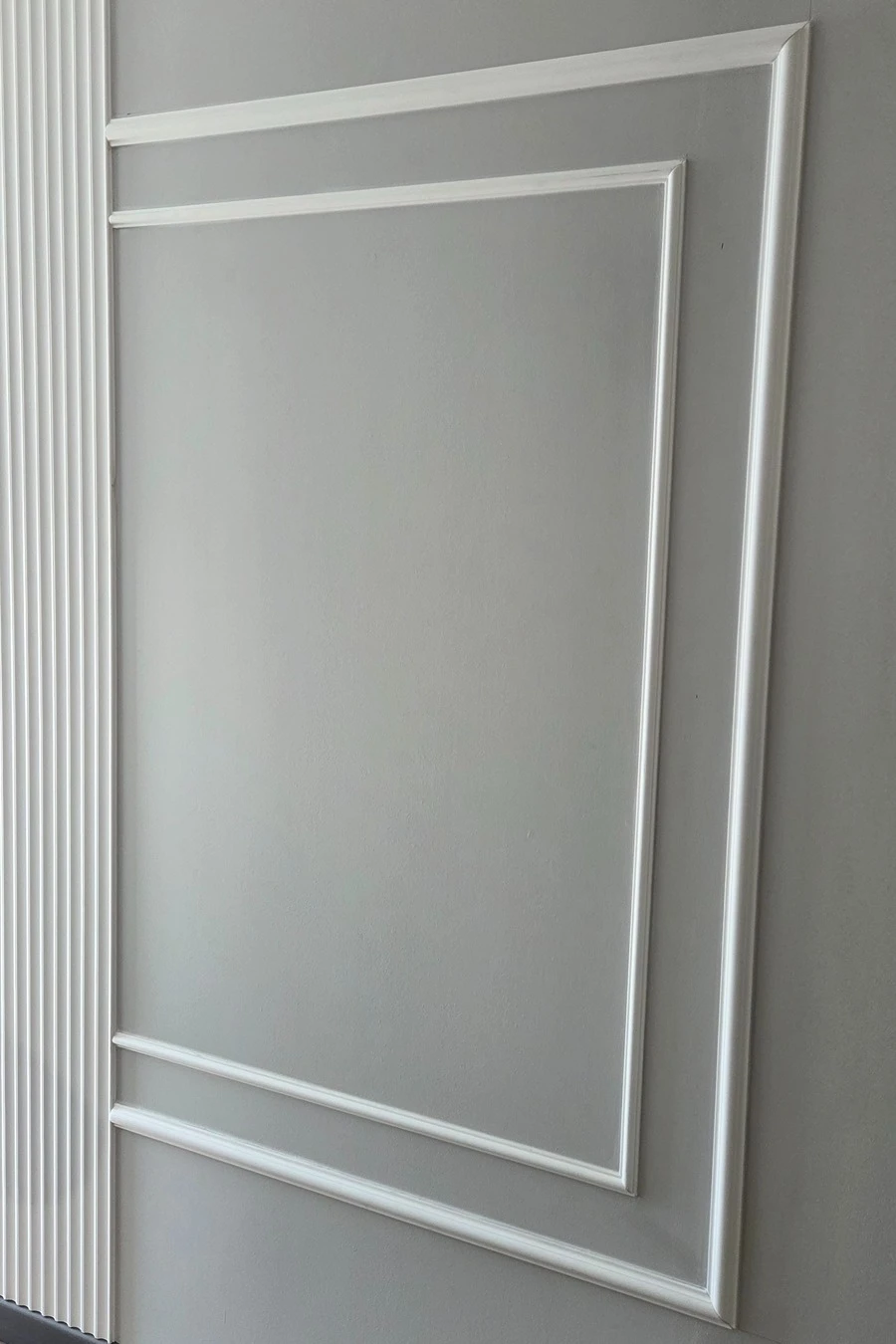 Perete vopsit cu chenare decorative albe, înainte de montarea platbandei din inox