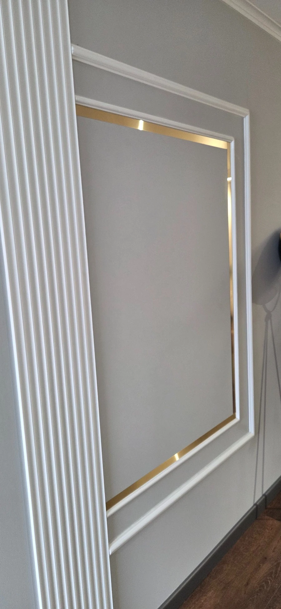 Rezultatul final al montajului, cu trei laturi de platbandă decorativă din inox auriu mat aplicate în interiorul chenarului