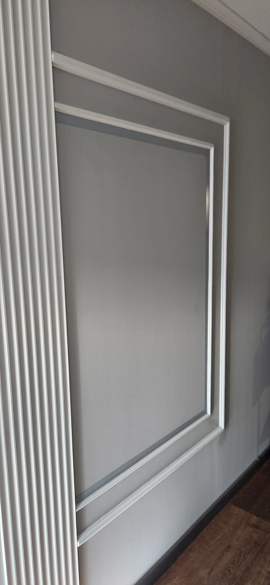 Chenar decorativ cu platbandă din inox montată pe trei laturi, înainte de îndepărtarea foliei de protecție